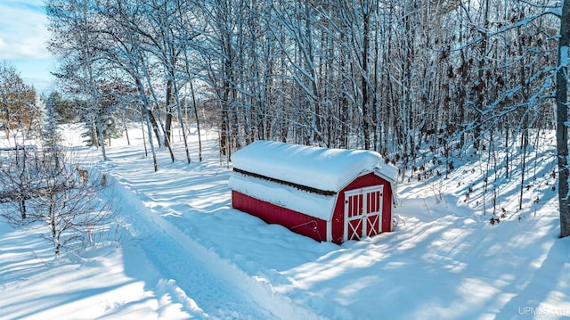 yard layered in snow featuring an outdoor structure