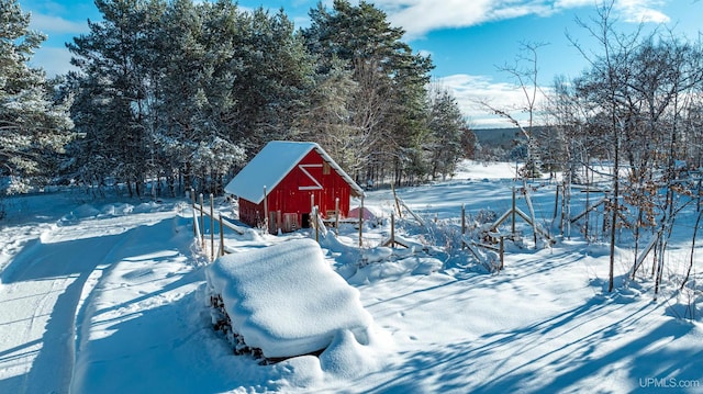 yard layered in snow with an outbuilding