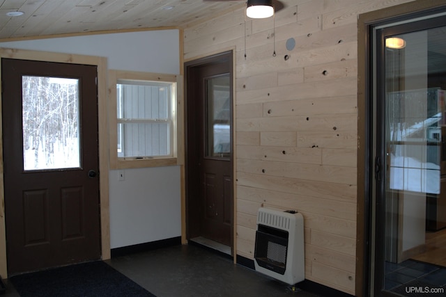 foyer featuring heating unit, wood walls, wood ceiling, and lofted ceiling