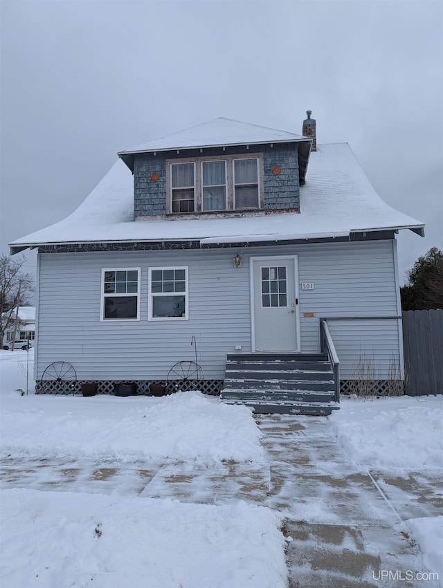 view of snow covered rear of property