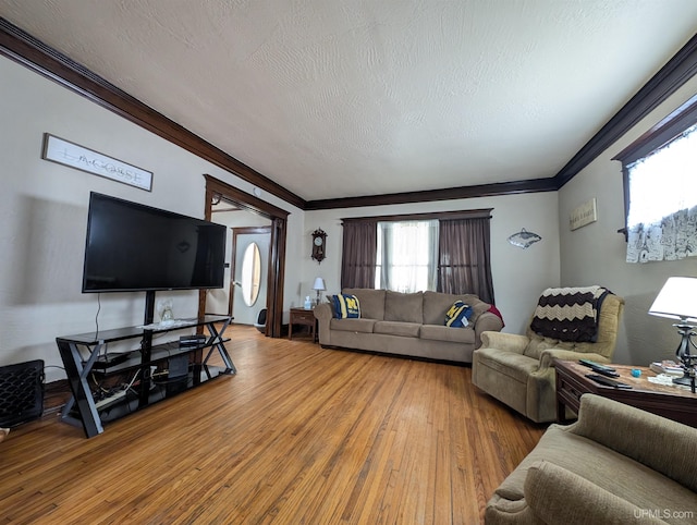 living room with crown molding, wood-type flooring, and a textured ceiling