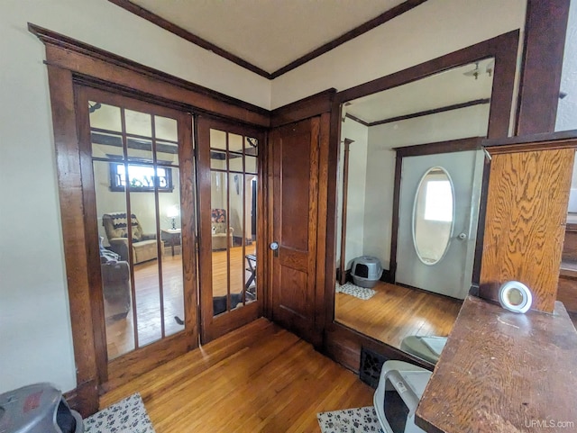 foyer entrance featuring hardwood / wood-style floors and crown molding