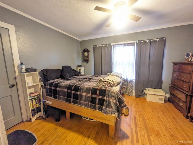 bedroom with ceiling fan, light hardwood / wood-style floors, and ornamental molding