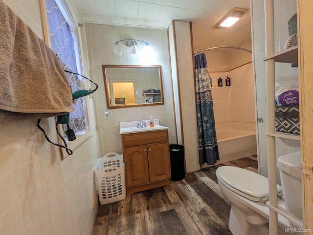 full bathroom with hardwood / wood-style floors, vanity, toilet, and shower / bath combo with shower curtain