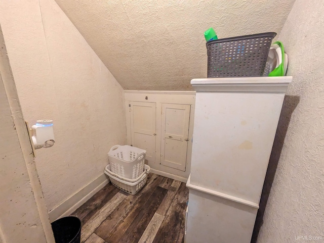 bathroom featuring hardwood / wood-style flooring and vaulted ceiling