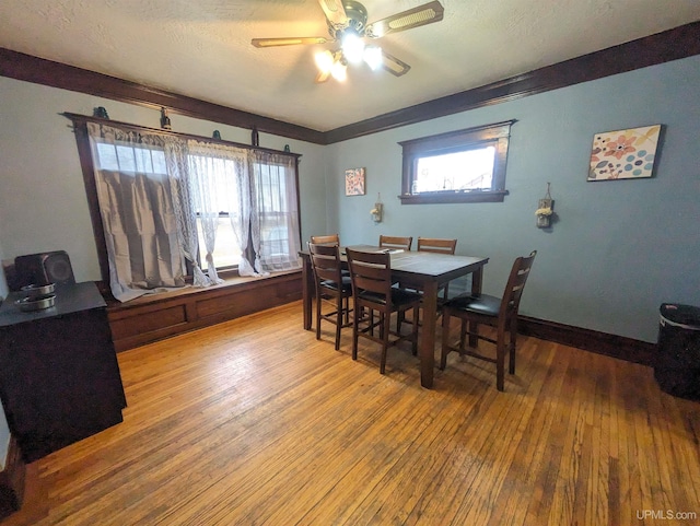 dining room featuring hardwood / wood-style flooring, ceiling fan, a healthy amount of sunlight, and a textured ceiling