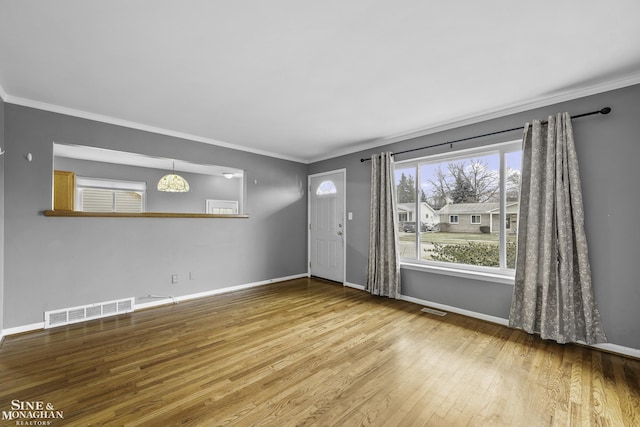 entryway with wood-type flooring and ornamental molding