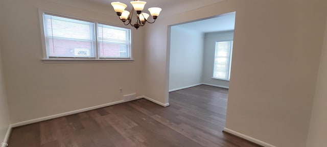 unfurnished dining area featuring a chandelier and dark hardwood / wood-style floors