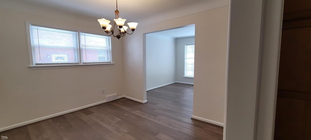 unfurnished dining area with a chandelier and wood-type flooring