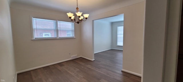 unfurnished dining area featuring dark hardwood / wood-style flooring and an inviting chandelier