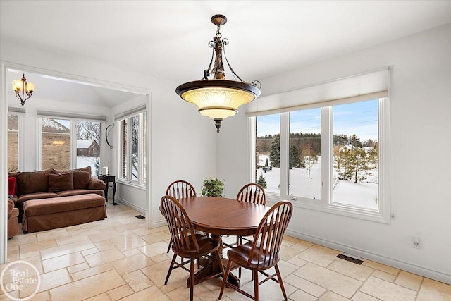 dining room featuring a healthy amount of sunlight and an inviting chandelier