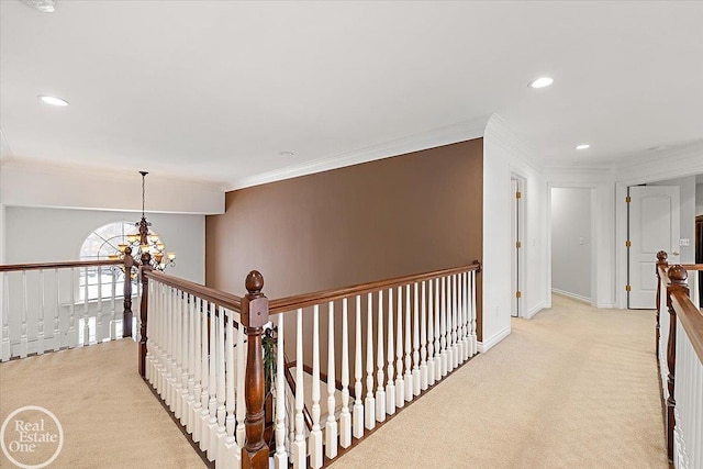 hallway featuring light carpet, ornamental molding, and a notable chandelier