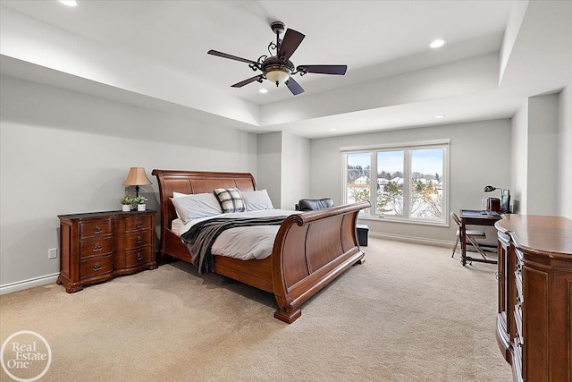 bedroom featuring ceiling fan, a raised ceiling, and light carpet