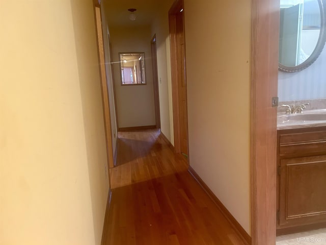 hall with sink and light wood-type flooring