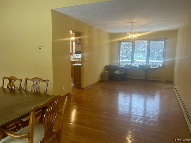 dining room featuring a baseboard heating unit, a notable chandelier, and dark hardwood / wood-style floors