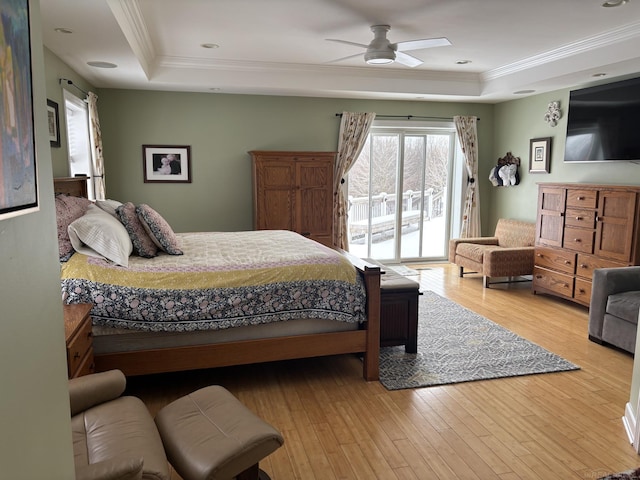 bedroom with access to outside, ceiling fan, light wood-type flooring, ornamental molding, and a tray ceiling