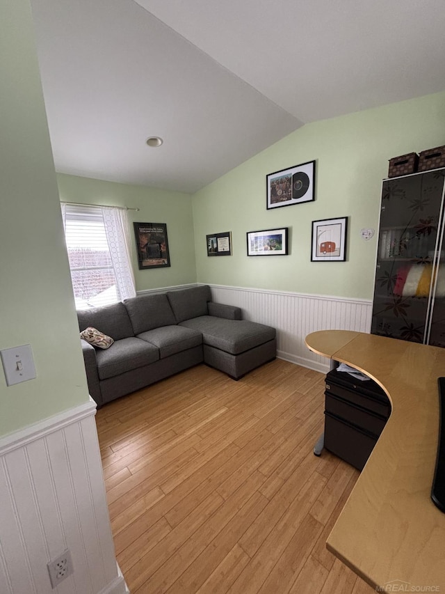 living room with light hardwood / wood-style floors and vaulted ceiling