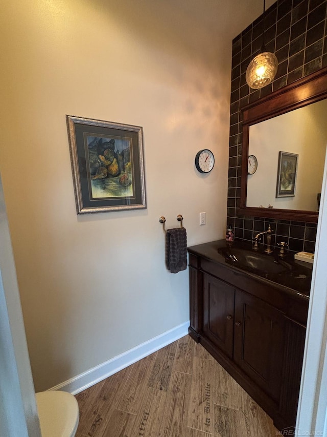 bathroom featuring wood-type flooring, vanity, and toilet