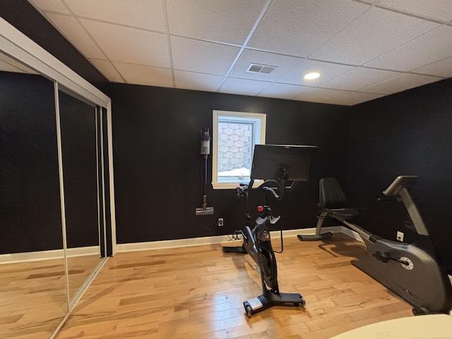 workout room featuring hardwood / wood-style flooring and a paneled ceiling