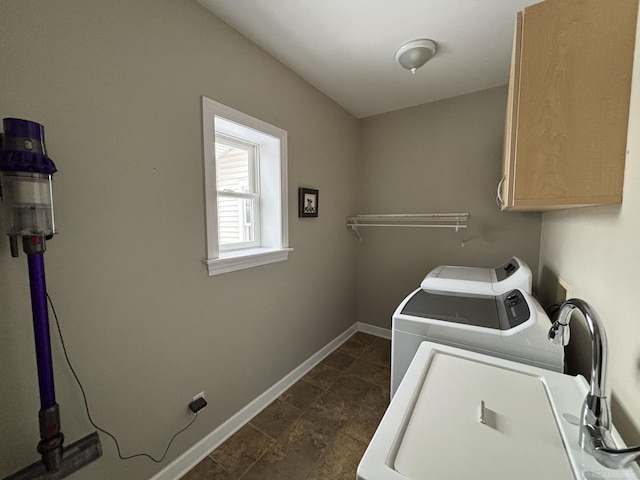 clothes washing area featuring cabinets and independent washer and dryer