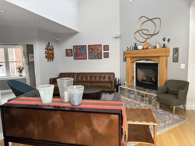 living room featuring wood-type flooring and a tile fireplace