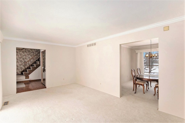 spare room featuring carpet flooring, crown molding, and a chandelier