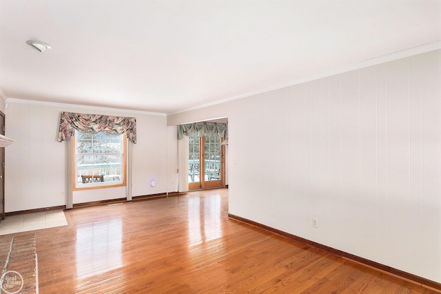 spare room with light wood-type flooring and ornamental molding