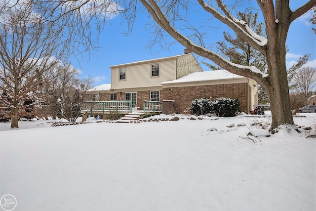 snow covered property with a wooden deck