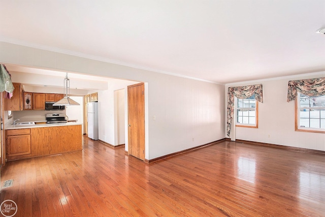 interior space featuring hardwood / wood-style flooring, ornamental molding, and sink