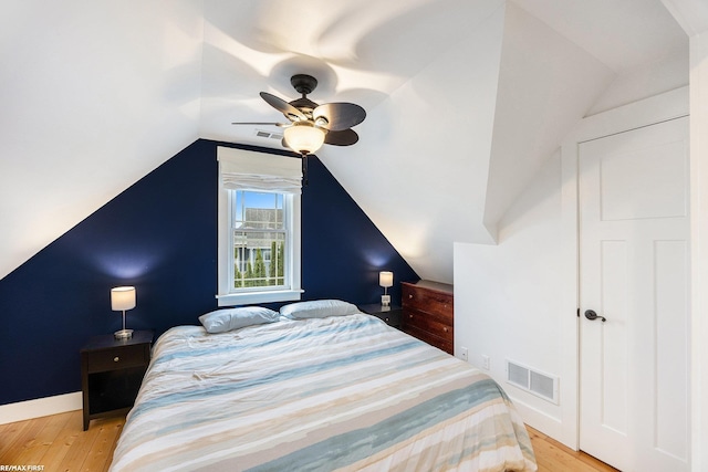 bedroom with ceiling fan, light wood-type flooring, and lofted ceiling