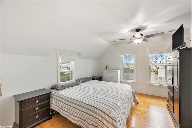 bedroom with multiple windows, ceiling fan, light hardwood / wood-style flooring, and lofted ceiling