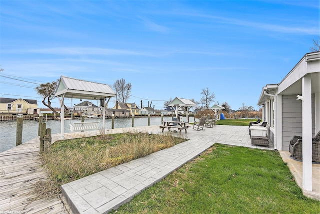 view of yard with a boat dock, a patio area, and a water view