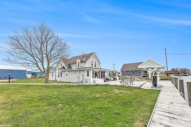 back of house with a yard and a patio