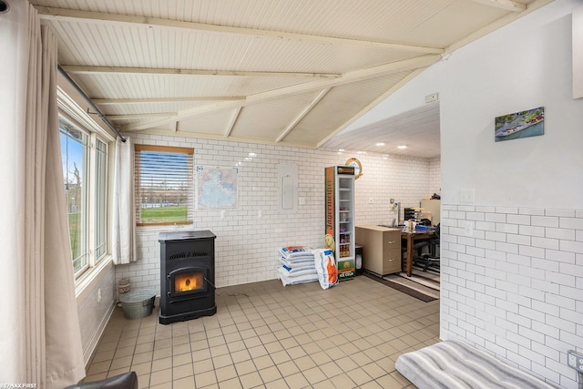 sunroom / solarium with vaulted ceiling with beams, electric panel, and a wood stove