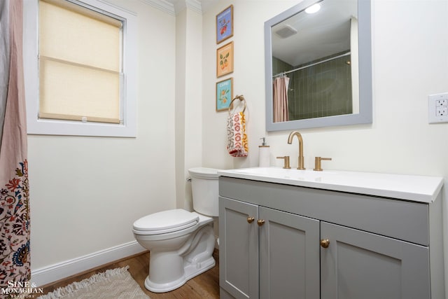 bathroom featuring hardwood / wood-style floors, vanity, toilet, and crown molding