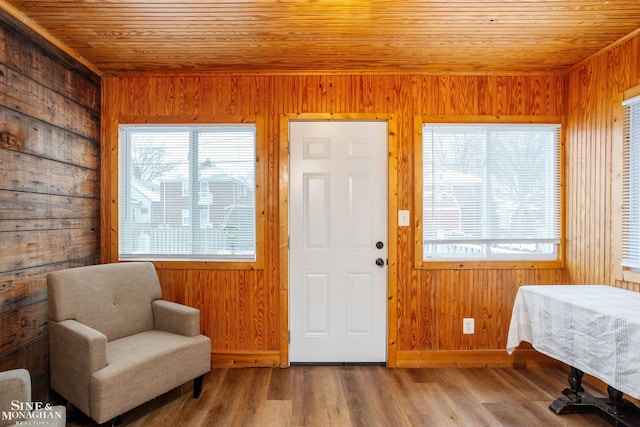 interior space featuring wood walls, wood ceiling, and light hardwood / wood-style flooring