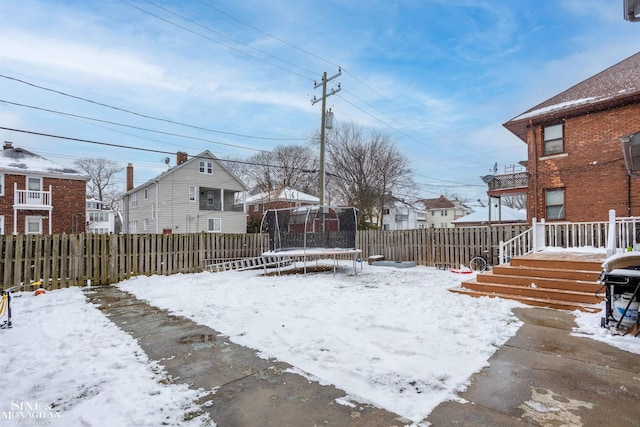 yard covered in snow featuring a trampoline