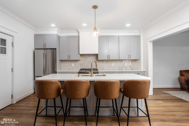 kitchen featuring gray cabinets, crown molding, sink, and stainless steel refrigerator