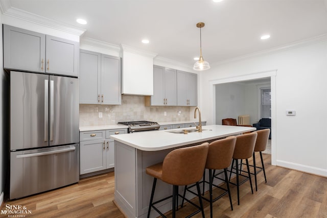 kitchen with sink, stainless steel appliances, light hardwood / wood-style flooring, gray cabinets, and a center island with sink