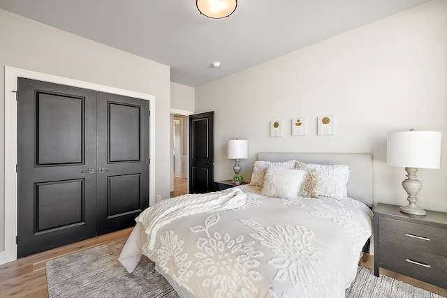 bedroom with light wood-type flooring and a closet