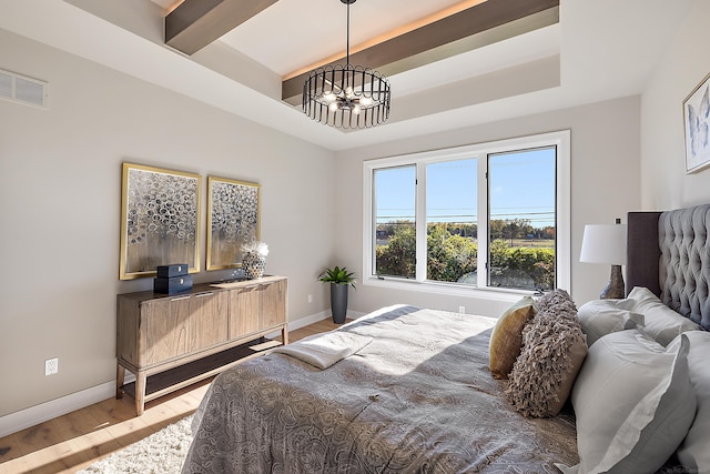 bedroom with hardwood / wood-style floors, a notable chandelier, and beam ceiling