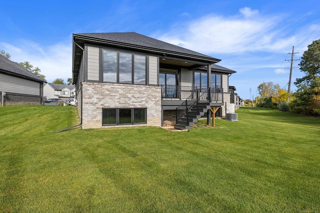 rear view of property with a yard and central AC