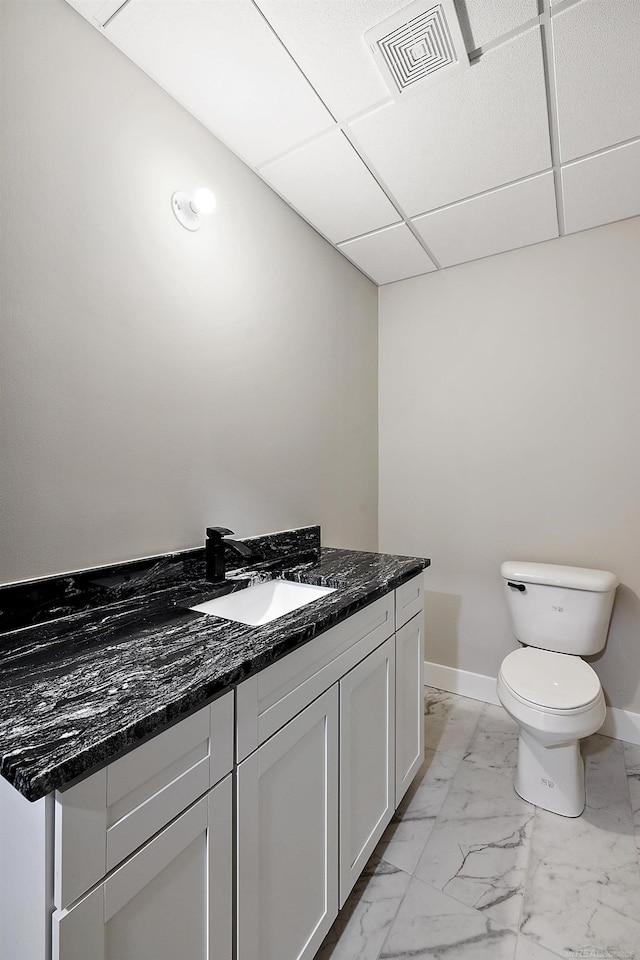 bathroom featuring a paneled ceiling, vanity, and toilet