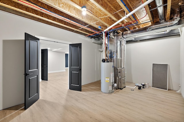 basement with water heater and hardwood / wood-style floors