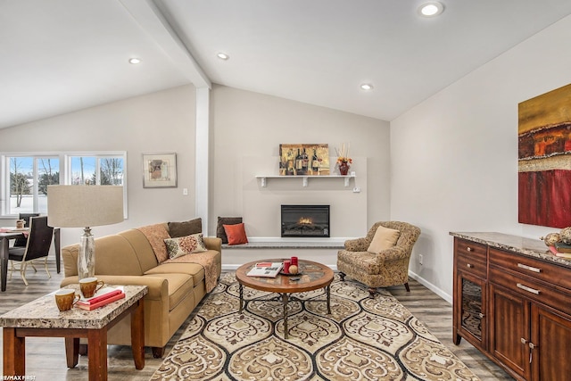 living room featuring lofted ceiling with beams and light hardwood / wood-style flooring