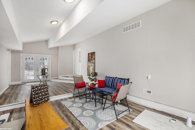 sitting room with dark hardwood / wood-style flooring, french doors, and vaulted ceiling