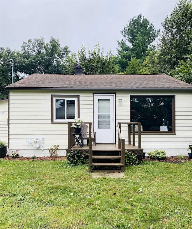 view of front of property featuring a front yard and a wooden deck