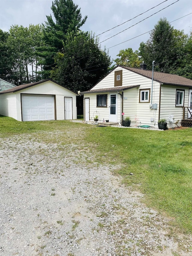 view of front facade featuring an outbuilding, a front yard, and a garage