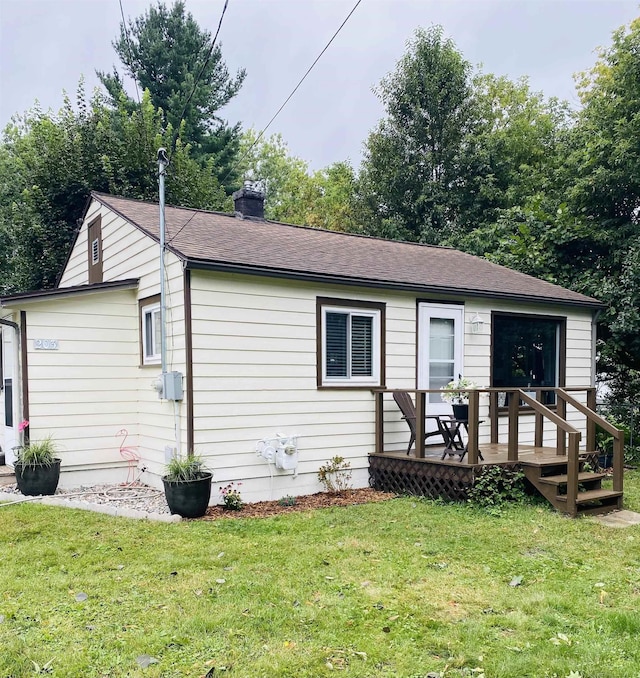 view of front of home with a front lawn and a wooden deck