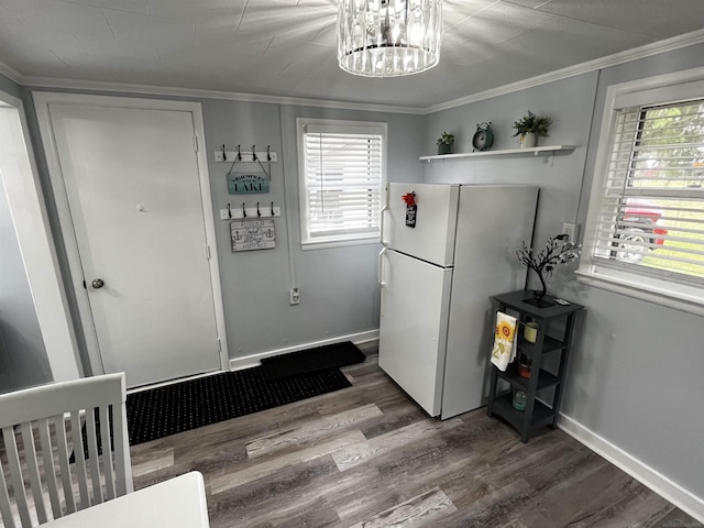 kitchen featuring an inviting chandelier, crown molding, wood finished floors, and freestanding refrigerator